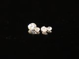 a pair of diamond earrings sitting on top of a black surface