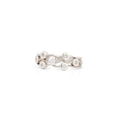 un gros plan d'une bague en or blanc sertie de diamants, sur fond blanc