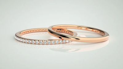 two rose gold wedding rings with diamonds on a white background
