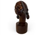 sculpture of a woman ' s head on a wooden base