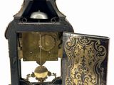 a black and gold clock with a bird on top of it