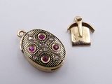 a close up of a gold locke with pink stones on it