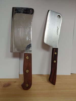 two knives that are sitting on a wooden table