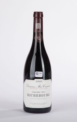 la bouteille de vin rouge est posée sur une surface blanche