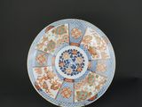 une assiette bleue et orange ornée d'un motif circulaire