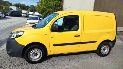 the yellow van is parked in the parking lot next to the building