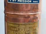 a large copper barrel that has a sign on it