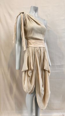 an image of a mannequin wearing a beige dress on a mannequin stand