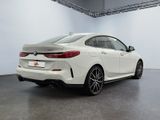 the rear end of a white bmw car in a white room