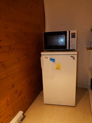 un petit réfrigérateur blanc dans le coin d'une cuisine