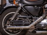 a black motorcycle parked in front of a brick wall