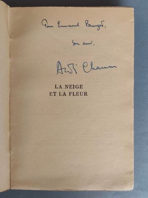 un livre ouvert, sur lequel figure un titre écrit à la main, posé sur une table