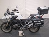 bmw motorcycle parked on a checkered floor with luggage on the back of it