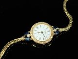 a close up of a watch on a chain with a chain around it