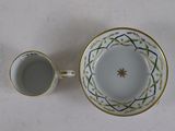 a cup and saucer sitting next to each other on a table
