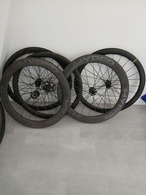 many different types of bicycle wheels lined up against a wall