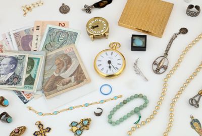 a white table topped with lots of jewelry and a clock