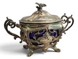 un bol ancien en argent et en verre bleu, muni d'un couvercle et orné d'un oiseau sur le dessus
