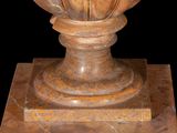 a vase that is sitting on a pedestal on a black background