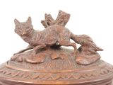 a bronze statue of a dog and a bird on a pedestal