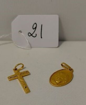 Deux croix en or et une pièce d'or sont posées sur une table