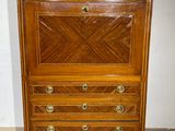 a wooden chest of drawers with a marble top