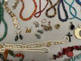 many different types of necklaces and bracelets laid out on a table