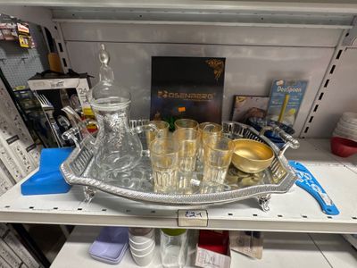 un plateau en argent sur lequel se trouvent des verres et une bouteille
