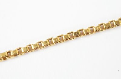 a close up of a gold chain on a white surface