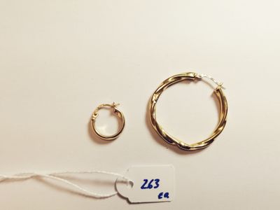 two pairs of gold hoop earrings and a pair of gold hoop earrings