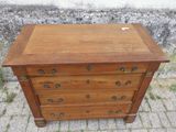 une vieille commode en bois posée sur un trottoir en briques