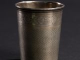 a close up of a silver cup on a black surface