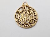 a gold plated pendant with a monogram in the center