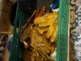 a green crate filled with dried bananas on the floor
