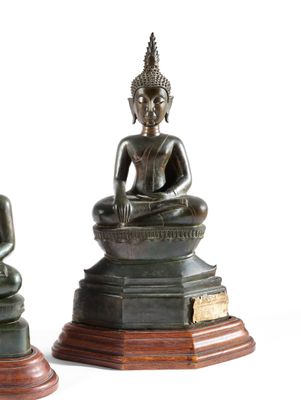 deux statues de Bouddha en bronze, assises sur un socle en bois