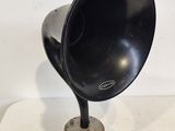 un gramophone noir et argenté posé sur un socle en bois, sur une surface blanche
