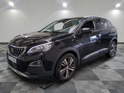une voiture noire est garée dans une pièce au sol en damier