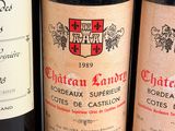 three bottles of red wine are lined up on a table