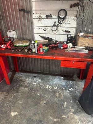 une table rouge sur laquelle sont posés des outils, dans un garage