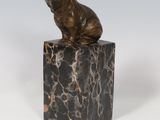 statue d'un ours assis sur un bloc de marbre, sur fond blanc