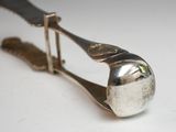 a silver spoon with a metal handle on a white surface
