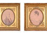 two framed portraits of a man and a woman in formal clothing