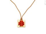 une image représentant un collier rouge et doré orné d'un caractère chinois