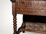 an old wooden table with a carved top and a drawer underneath it