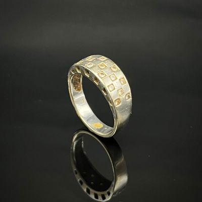 gros plan d'une bague en argent sur une surface noire