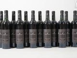 six bouteilles de vin sont alignées sur une table