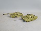 two toy tanks sitting side by side on a white surface