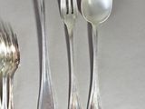 a lot of silver spoons and silverware on a table