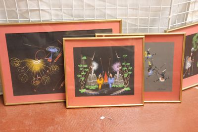 three framed pictures of people and animals are on a table