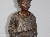 bronze statue of a boy with a hat and a baseball cap